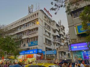 a busy city street with a tall building at Hotel Parklane in Mumbai