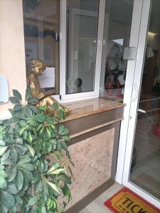 una estatua de bronce sentada en la parte delantera de un edificio en ALBERGUE EZEQUIEL, en Melide