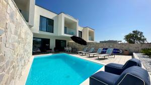 a villa with a swimming pool in front of a house at Lemon Navy house in Vodice