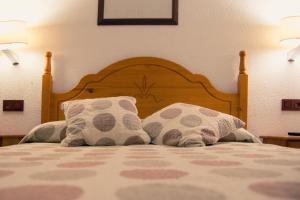 a bedroom with a bed with two pillows on it at Hostal La Toba in Cañete