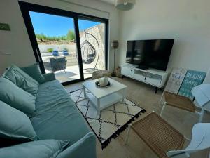 a living room with a blue couch and a tv at Lemon Navy house in Vodice
