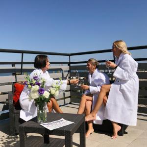 Tres mujeres sentadas en un balcón bebiendo vino en Continental Hotel, en Odessa