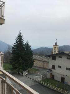 a pine tree in a parking lot next to a building at Pian Munè appartamento (San Lorenzo) in Paesana