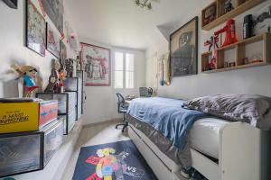 een slaapkamer met een bed, een bureau en planken bij Magnifique appartement Lumineux in Saint-Mandé