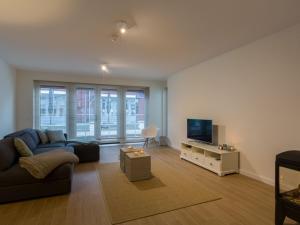 een woonkamer met een bank en een flatscreen-tv bij Elegant Apartment in Koudekerke with Gas Fireplace in Koudekerke