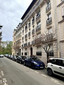 eine Reihe von Autos, die vor einem Gebäude geparkt sind in der Unterkunft Magnifique appartement Lumineux in Saint-Mandé