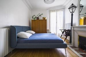 ein blaues Sofa im Wohnzimmer mit Kamin in der Unterkunft Magnifique appartement Lumineux in Saint-Mandé