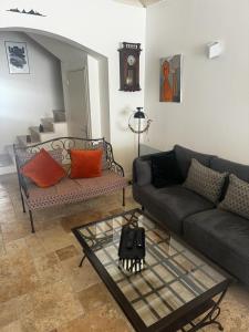 een woonkamer met een bank en een tafel bij La maison de Marie, maison de ville 4 personnes, option chambre patio 2 pers supp in Aigues-Mortes