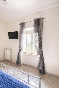 - une chambre avec un lit et une fenêtre avec des rideaux dans l'établissement Testaccio appartamento per gli amanti di un caffè in terrazzo, à Rome