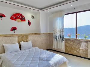 a bedroom with a bed and a window with umbrellas at ZoZo House - Homestay Bai Sau 77 in Vung Tau