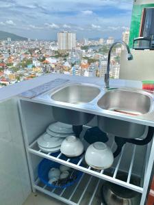 a kitchen with two sinks and a view of a city at ZoZo House - Homestay Bai Sau 77 in Vung Tau