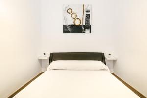 エンプリアブラバにあるPANORAMIC D-LUXEの白い部屋のベッド1台(テーブル2台付)