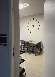 uma sala de jantar com uma mesa e um relógio na parede em Casa Ari em Desenzano del Garda