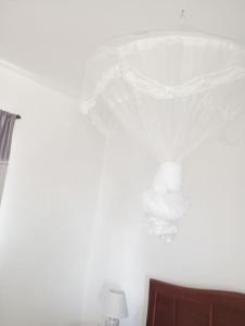 una camera da letto con una parete bianca e una lampada di Kaza Mamai di Fora, o conforto da sua estadia a Calheta
