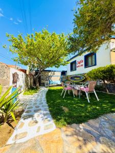 a garden with a table and chairs and a tree at Cagla Hotel in Ildır