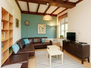 sala de estar con sofá de cuero y TV en Spacious Mansion in Swolgen with Garden en Swolgen