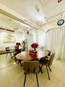 a dining room with two tables and chairs and a clock at Toi's Travel Home Central in Ho Chi Minh City