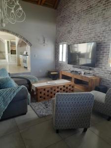 a living room with a large flat screen tv at Zeezicht Villa - Jacobsbaai in Jacobs Bay