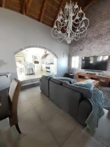 salon z kanapą i żyrandolem w obiekcie Zeezicht Villa - Jacobsbaai w mieście Jacobs Bay