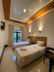 a hotel room with two beds and a window at Villa Padi Pakem in Pakem
