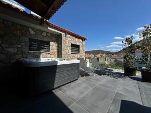 a backyard patio with a tub and a stone building at Amfikleias Earth houses in Amfiklia