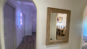 uno specchio a parete in una stanza con tavolo di Rosdani a Palermo