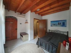 1 dormitorio con cama y techo de madera en Villa Sabrina, en Milatos