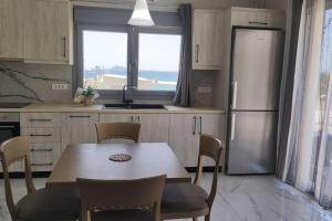 a kitchen with a table and chairs and a refrigerator at SUITE Thalassa - with Jacuzzi in Kalamaki