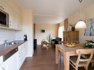 eine Küche und ein Wohnzimmer mit einem Holztisch in der Unterkunft Cozy house with or without hot tub near a river in Notter