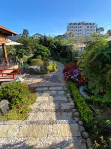 a garden with a stone path and flowers at Twin Villa Village Đà Lạt in Da Lat