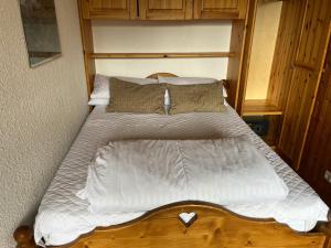 a bed with white sheets and pillows in a bedroom at La Villaret in Les Menuires