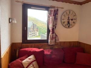 a room with a couch and a clock on the wall at La Villaret in Les Menuires