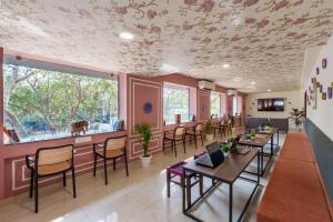 a restaurant with tables and chairs and a ceiling with flowers at The Hosteller Jaipur, MI Road in Jaipur