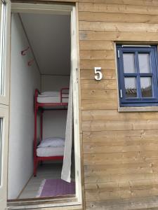a tiny house with a bunk bed and a window at Sovgodt Nyord in Nyord