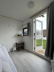 a bedroom with a bed and a large window at Sovgodt Nyord in Nyord