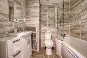 La salle de bains est pourvue de toilettes, d'une baignoire et d'un lavabo. dans l'établissement Stylish 2 Bed Flat Close To Nec Bhx, à Solihull
