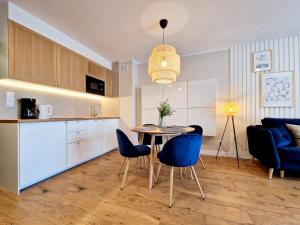 kuchnia i jadalnia ze stołem i krzesłami w obiekcie Avangard by Baltic Home w Świnoujściu
