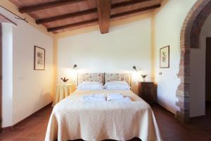 a bedroom with a large bed with a white blanket at Agriturismo Bio Aia Della Colonna in Saturnia