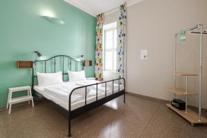 1 dormitorio con 1 cama con pared azul en Wombat's City Hostel Budapest, en Budapest