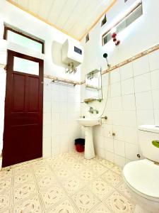 a bathroom with a toilet and a sink and a door at Thanh Lam Hotel in Sầm Sơn