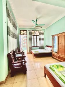 a living room with a bed and a couch and chairs at Thanh Lam Hotel in Sầm Sơn