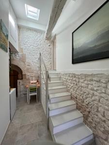 escalera en una habitación con pared de piedra en Cosy apartment with swimming pool near Aubeterre, en Saint-Romain