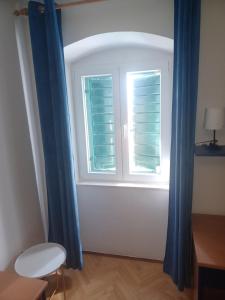 uma janela com cortinas azuis num quarto em Spalato em Split