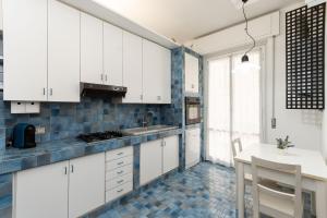 a kitchen with white cabinets and a blue tile floor at IMMOBIRENT - 5min spiagge - 15min centro città in Genoa