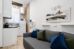 ein Wohnzimmer mit einem grauen Sofa und einer Küche in der Unterkunft Studio with loft - San Isidro - L1 in Madrid