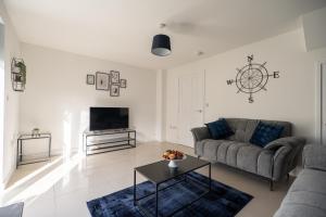 een woonkamer met een bank en een tafel bij Kingfisher House By Horizon Stays in Stockton-on-Tees
