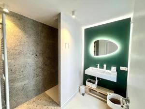 een badkamer met een groene muur en een wastafel bij Duplex chic et spacieux - Hypercentre in Luik