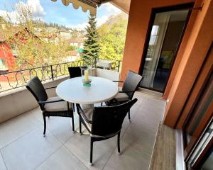 a table and chairs on a balcony with a window at Ascona: ORTO DEGLI ANGIOLI in Ascona