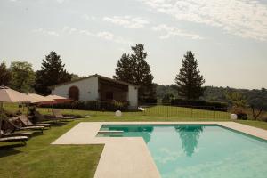 a swimming pool in a yard with chairs and a house at Agriturismo Bio Aia Della Colonna in Saturnia