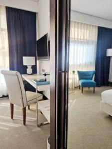 une chambre d'hôtel avec un bureau, un canapé et une table dans l'établissement Hotel Nuevo Boston, à Madrid